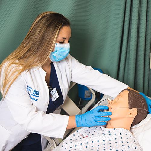 nursing student practicing giving oxygen to a dummy patient